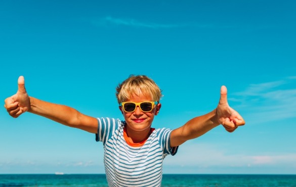 young boy giving thumbs up on the beach | SeaShore Realty