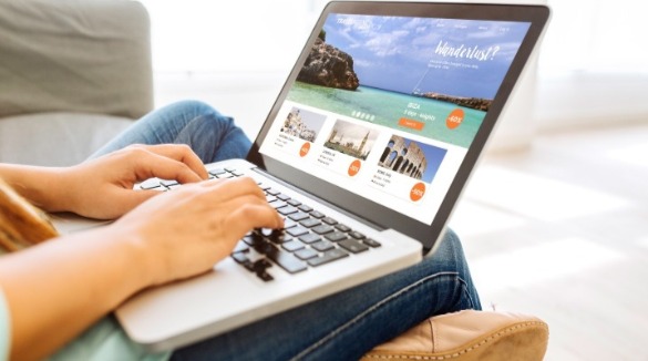 woman planning beach vacation on laptop | SeaShore Realty