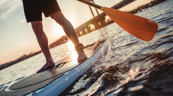 man stand up paddle boarding | SeaShore Realty