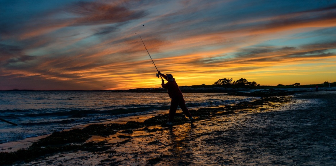 man surf fishing at sunset | SeaShore Realty