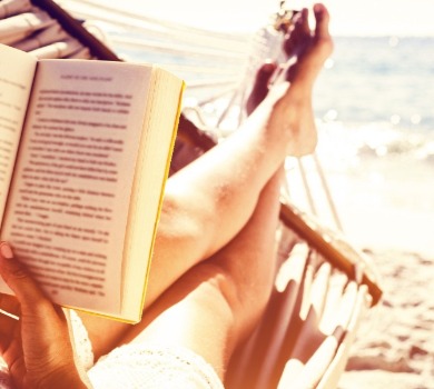 person reading a book on the beach | SeaShore Realty
