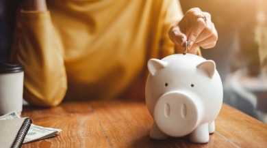 dropping money into piggy bank | seashore realty