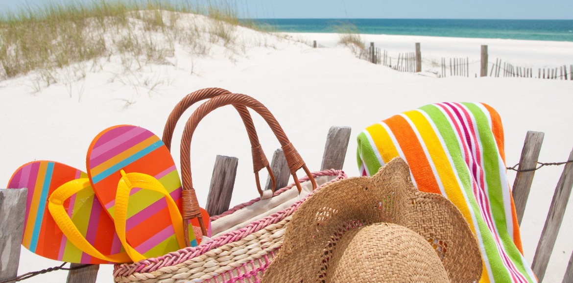 beach items and beach bag sitting on the beach | SeaShore Realty