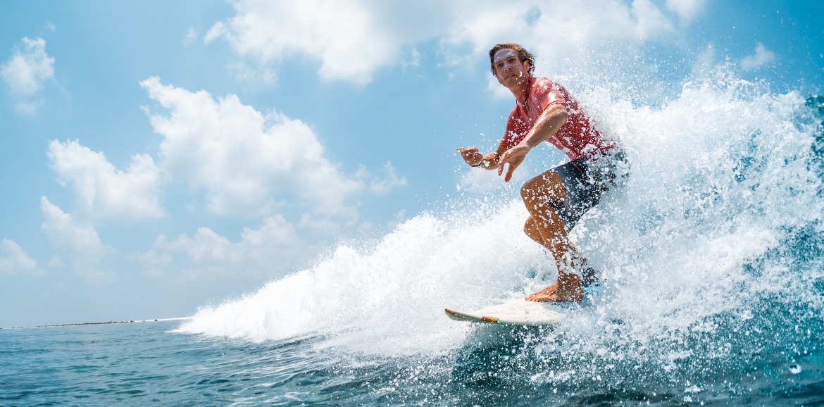 man surfing in the ocean | seashore realty